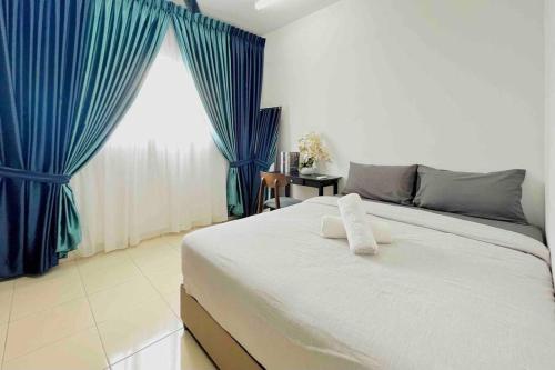 a bedroom with a large white bed with blue curtains at Studio Room Alanis Suite @ KLIA in Sepang