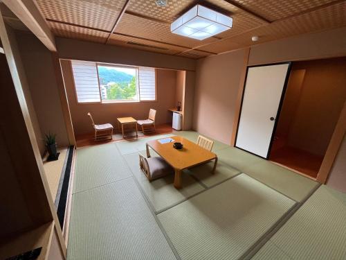 a room with a table and chairs and a window at Jozankei Daiichi Hotel Suizantei in Jozankei