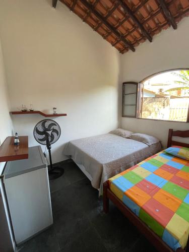 1 dormitorio con 2 camas y ventana en Angra dos Reis - Casa pé na areia na Praia de Fora - Ponta Leste, en Angra dos Reis