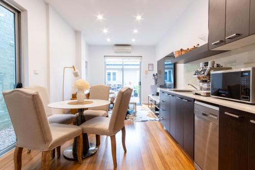 a kitchen and dining room with a table and chairs at Eggies Nest - Sydney City Apartment in Sydney