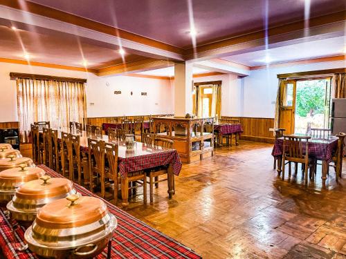 a restaurant with tables and chairs in a room at Hotel shaynam in Leh