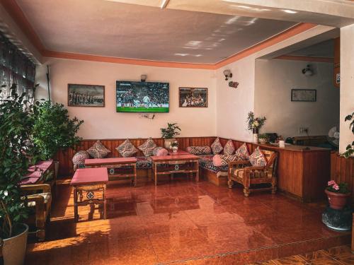 a living room with couches and a tv on the wall at Hotel shaynam in Leh