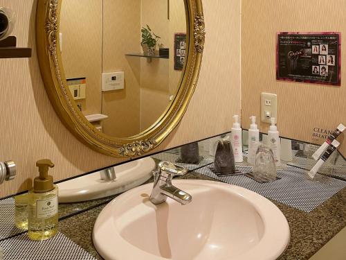 a bathroom with a sink and a mirror at Restay Puchi Nagasaki Club (Adult Only) in Nagasaki