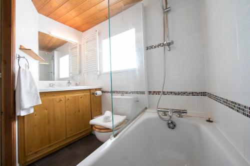 a bathroom with a tub and a toilet and a sink at Résidence Igloo 3 ski in-ski out - Happy Rentals in Le Tour