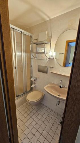 RATSKELLER Hotel & Restaurant في كروف: حمام مع حوض ومرحاض ومرآة