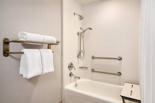 La salle de bains est pourvue d'une baignoire blanche, d'une douche et de serviettes. dans l'établissement Courtyard Ewing Hopewell, à Ewing