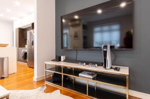 uma sala de estar com televisão na parede em Eggie's Nest - Luxury City Apartment em Sidney