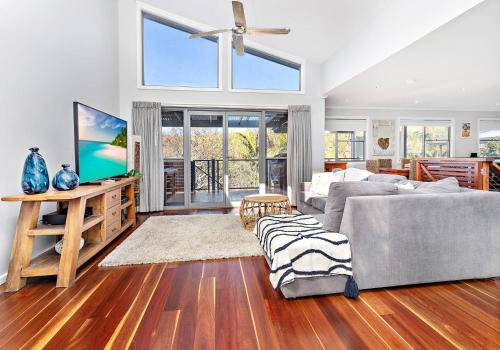 a living room with a couch and a tv at Cookes Haven in Gerringong