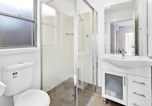 uma casa de banho branca com um WC e um lavatório em Cookes Haven em Gerringong
