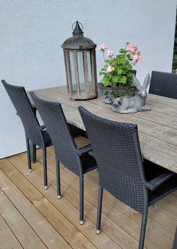 a wooden table with chairs and a lamp on a deck at Mysigt hus i liten by nära havet in Ystad