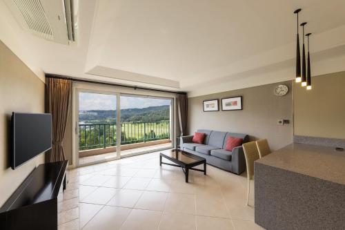 a living room with a couch and a large window at Oak Valley Resort Valley Village in Wonju
