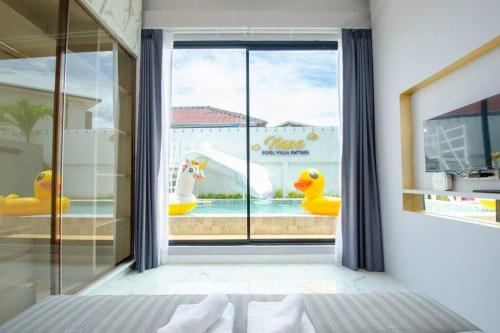 a room with a window with a view of a pool at Napa Pool Villa Pattaya in Nong Prue