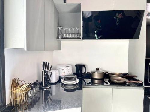 a kitchen with white cabinets and pots and pans at Napa Pool Villa Pattaya in Nong Prue