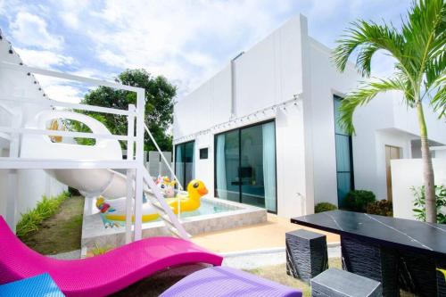 a backyard with a pool with a slide and a play area at Napa Pool Villa Pattaya in Nong Prue