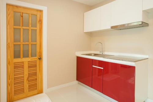 a kitchen with a red cabinet and a sink at ROYAL GRAND PATTAYA in Nong Prue