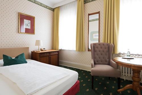 a hotel room with a bed and a desk and a chair at Boutique-Hotel Amalienhof in Weimar