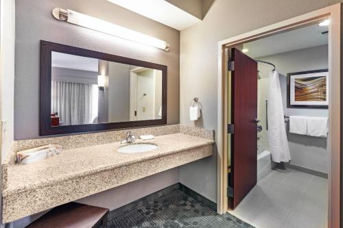 a bathroom with a sink and a mirror at Courtyard by Marriott Tulsa Woodland Hills in Tulsa