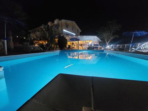 a swimming pool at night with blue lights at Hotel Piccolo Mondo in Acquappesa