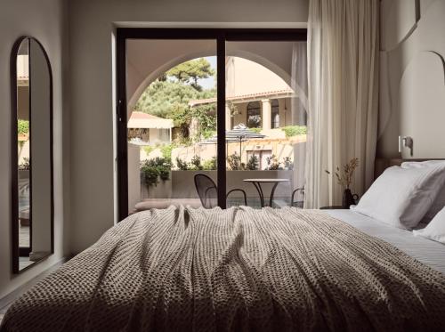 a bedroom with a bed and a large window at Hotel Pallas in Laganas