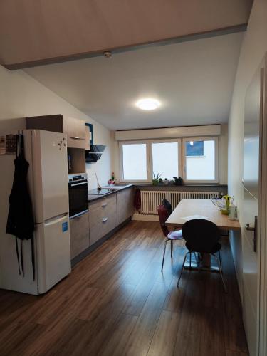une cuisine avec une table et un réfrigérateur blanc dans l'établissement Chez Mamie, à Metz