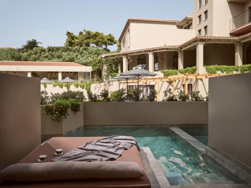 a swimming pool in front of a house at Hotel Pallas in Laganas