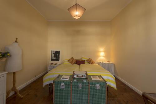 a bedroom with a bed with a green suitcase at Family House Garden in Ponta Delgada