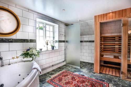 a bathroom with a tub and a window at Vadstena Klosterhotell Konferens & Spa in Vadstena