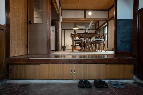 a dining room with a table and two pairs of shoes at 【70平米 長期予約大歓迎】6LDK/日本家屋貸切/大人数で寛げる空間 in Tokyo