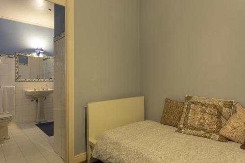 a bedroom with a bed and a bathroom with a sink at Family House Garden in Ponta Delgada