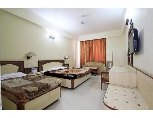 a hotel room with two beds and a television at Vishal Hotel, Katra in Katra
