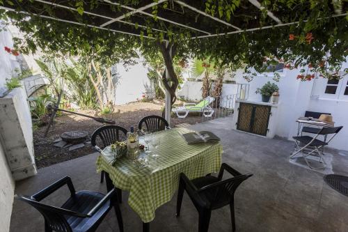 a table and chairs on a patio under a tree at Family House Garden in Ponta Delgada