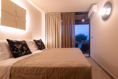a bedroom with a bed with a large window at Marni Village in Hersonissos