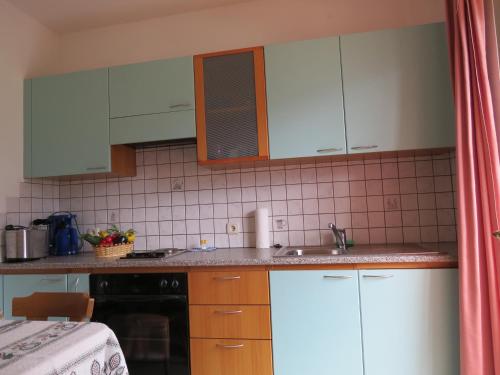 a kitchen with white cabinets and a sink at Agriturismo Kabishof in Funes