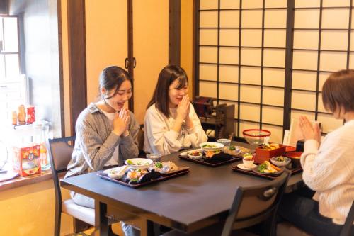 two women sitting at a table eating food at Kona Stay Bicycle Resort in Izunokuni