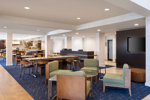 un ristorante con tavolo, sedie e TV di Courtyard Salt Lake City Airport a Salt Lake City