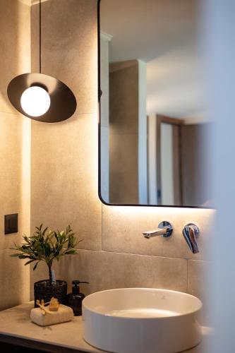 a bathroom with a sink and a large mirror at Marni Village in Hersonissos