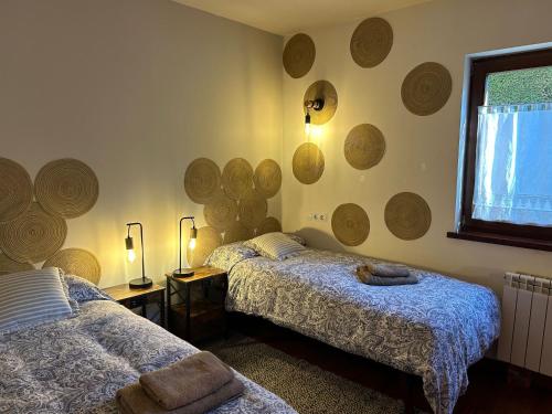 two beds in a room with wooden rounds on the wall at Casa en la Molina in La Molina