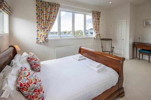 a bedroom with a bed and a desk and windows at Summer Lake 32B, Meadowlark in South Cerney