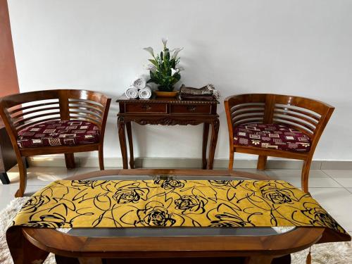 a room with two chairs and a table with a yellow blanket at Ilsham Guest House @ Seroja Hills BBST Sepang in Sepang