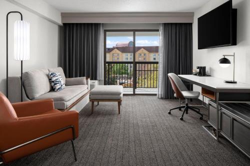 a living room with a couch and a desk at Courtyard Jacksonville Butler Boulevard in Jacksonville