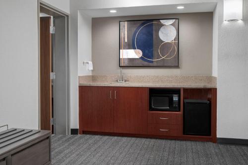 a kitchen with a sink and a microwave at Courtyard Jacksonville Butler Boulevard in Jacksonville