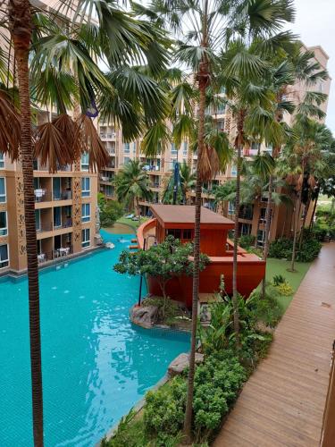 une vue sur la piscine d'un complexe hôtelier avec des palmiers dans l'établissement Atlantis Condo Resort Атлантис кондо резорт, à Jomtien Beach