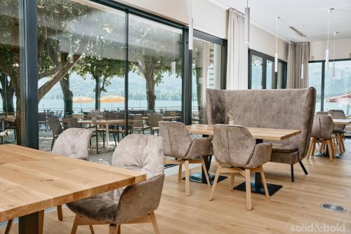 a restaurant with wooden tables and chairs and windows at Hotel Weisser Hirsch in St. Wolfgang
