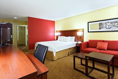 a hotel room with a bed and a red wall at Courtyard Houston/Brookhollow in Houston