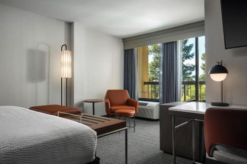 a hotel room with a bed and a chair at Courtyard by Marriott Santa Rosa in Santa Rosa