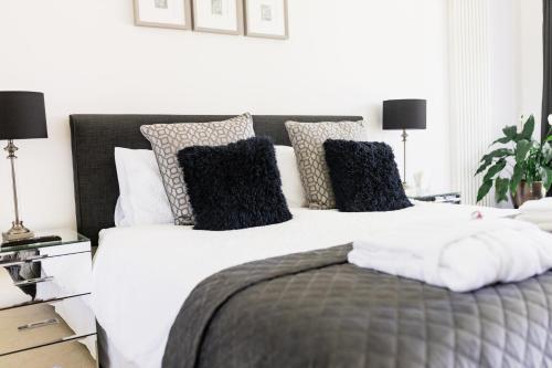 a bedroom with a large bed with black and white pillows at Boswenna in St Ives