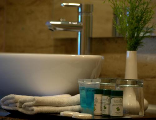 a bathroom counter with a sink and a towel and cosmetics at Himalaya Drishya Resort in Dhulikhel