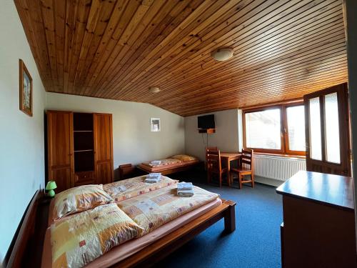 a bedroom with a bed and a wooden ceiling at Penzión Mizuna in Hrabušice