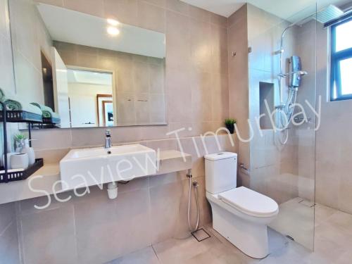 Un baño con lavabo, inodoro y espejo. en Seaview Timurbay Kuantan, en Kuantan