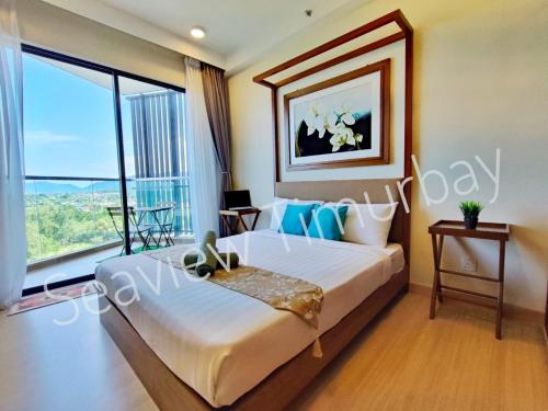 Un dormitorio con una cama grande y una ventana grande. en Seaview Timurbay Kuantan, en Kuantan